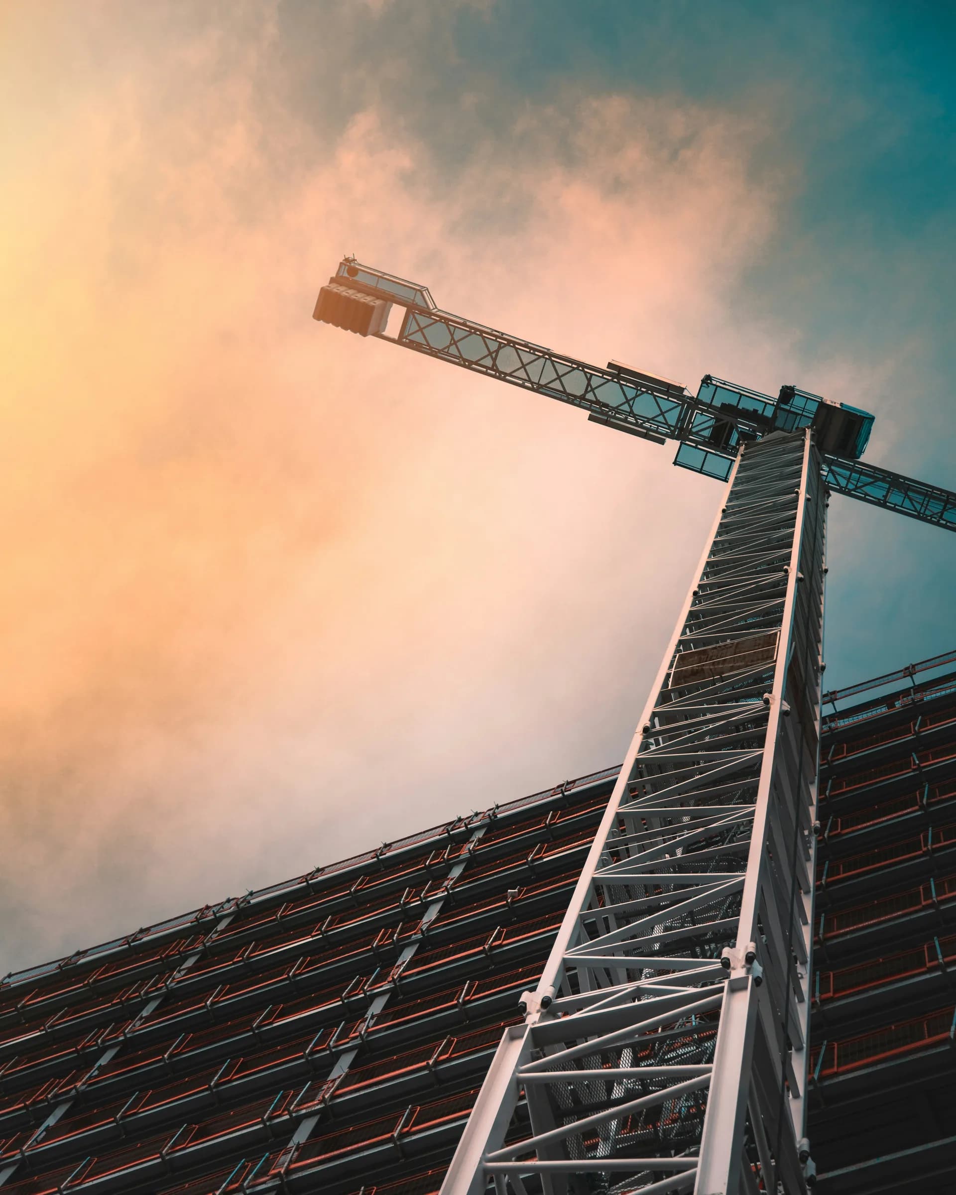 Construction crane silhouetted against a sunset sky at a Canadian build site