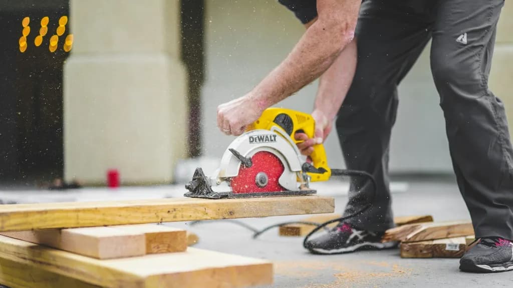 Trade worker cutting lumber with a circular saw, sawdust in the air